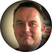 Close-up of a person smiling with a blurred background.