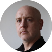 Person with a neutral expression against a plain background.