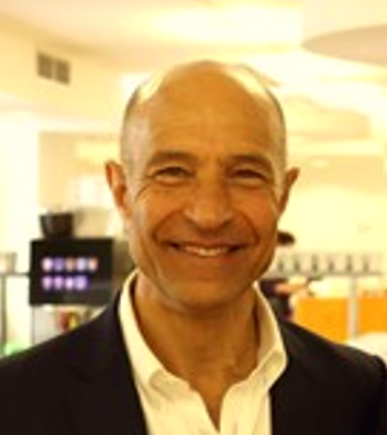 Person smiling in an office setting with a warm background glow.