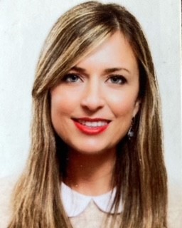 Person smiling with long hair in a professional headshot.