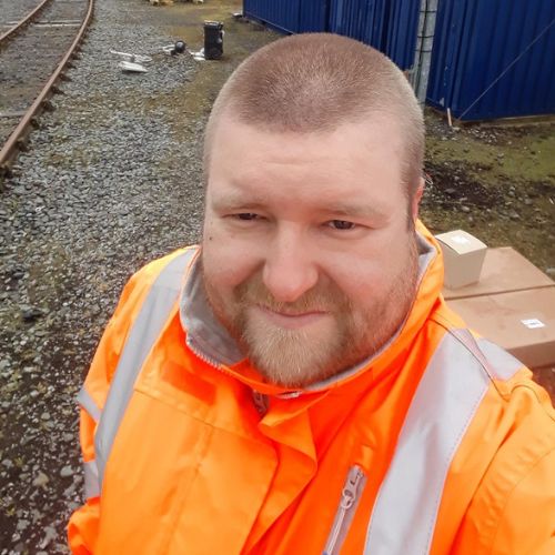 Person in orange safety gear at a construction site.