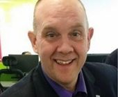 Person smiling indoors with an office background.