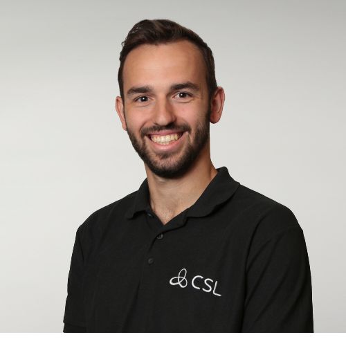 Person smiling in a black polo shirt with CSL logo on the left side.