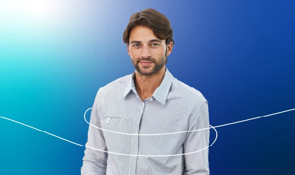 A young man dressed in business casual smiles confidently