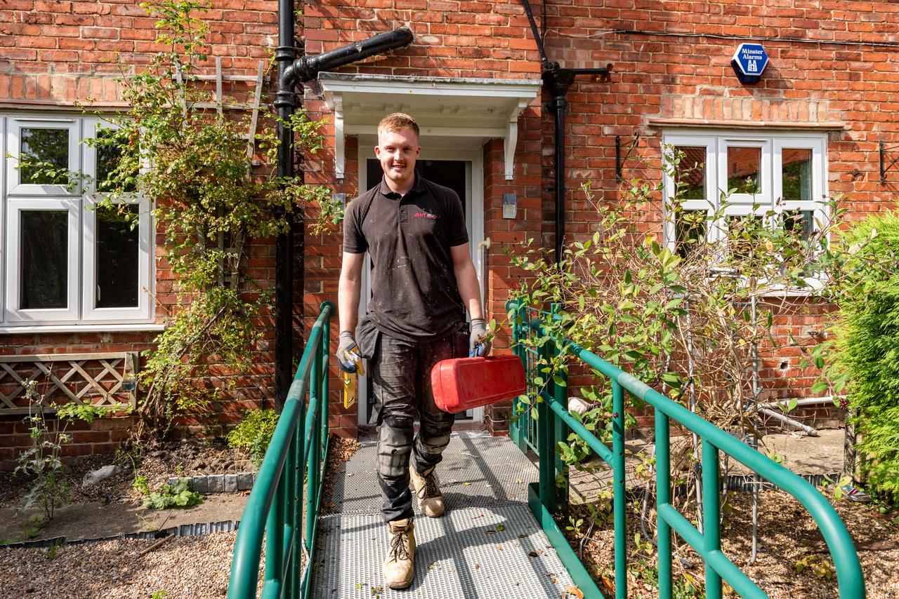 man with toolbox outside building