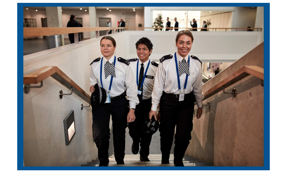 a male and two female officers on stairs