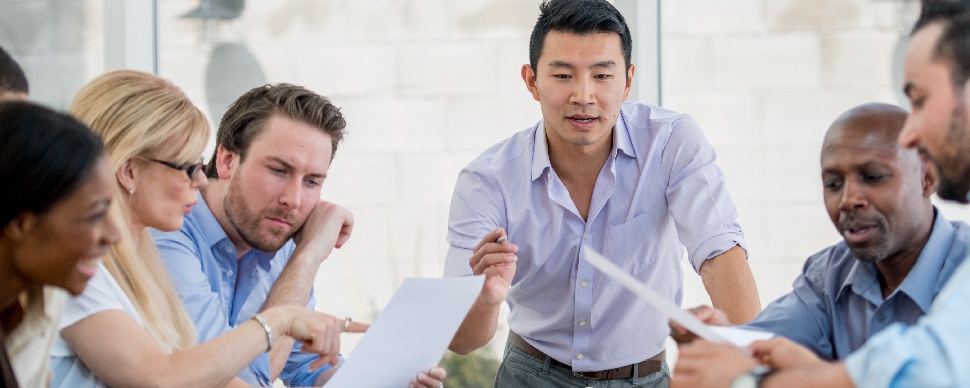 Diverse group of professionals engaged in a discussion in an office setting 