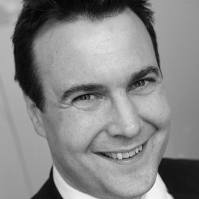 Smiling person in a suit, closely cropped image.