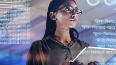 Person holding a tablet with digital code overlay.