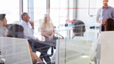 A group of people in a modern office having a meeting.