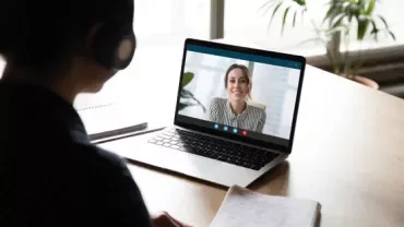 Two people having a video call on a laptop.