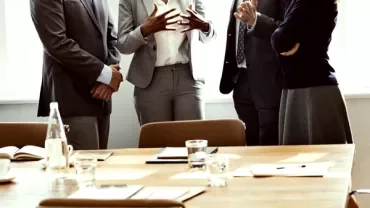 Professionals engaged in a discussion around a conference table.