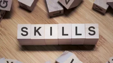 Wooden blocks spelling 'SKILLS' on a wooden surface.