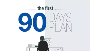 Person at desk with computer under 'The First 90 Days Plan' text.