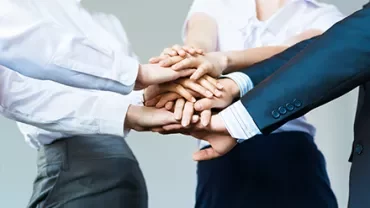 Diverse group stacking hands in solidarity.