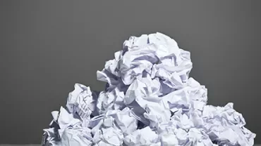 Pile of crumpled white paper against a gray background.