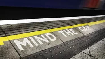 Train platform edge with 'Mind the Gap' warning.