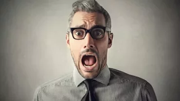 Person wearing glasses and a striped shirt with a surprised expression.