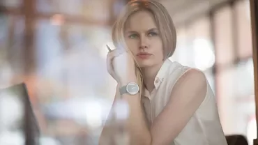 Person looking thoughtful while sitting in a cafe with a notebook.