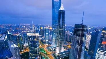 A vibrant cityscape at dusk with illuminated skyscrapers and a bustling skyline.