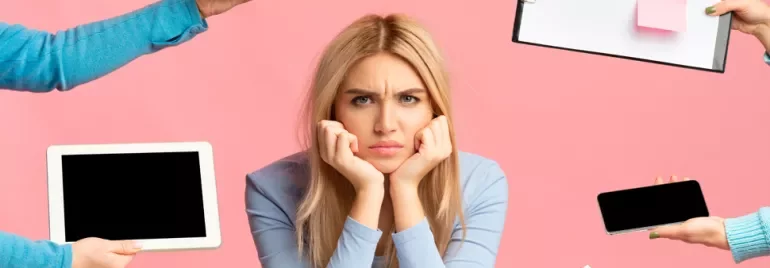 Person looking frustrated while surrounded by digital devices and a clipboard against a pink background.