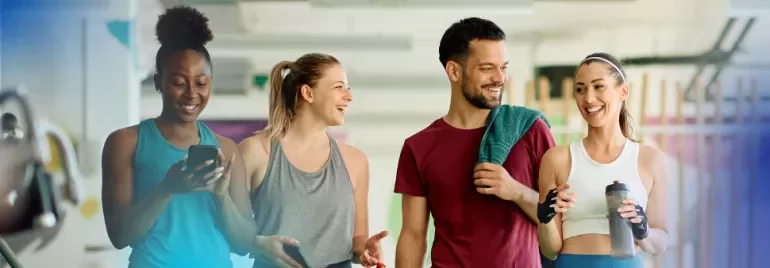 Group of friends smiling and chatting at the gym.