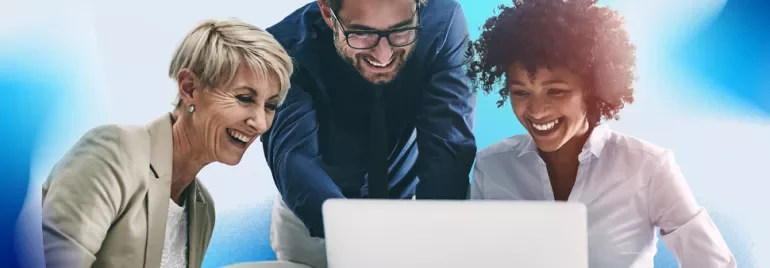 A group of three people is focused on a laptop, sharing insights about pay transparency on the display
