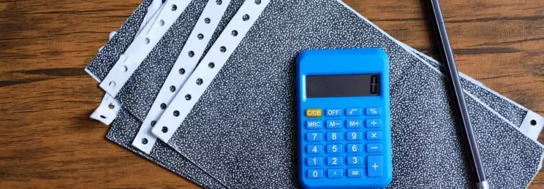 a calculator and pen on top of payslips