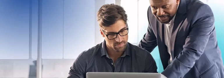 two men looking at a computer