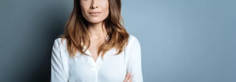 Person in white shirt with arms crossed, wearing a smartwatch.