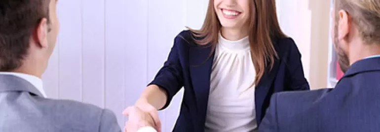 Person smiling and shaking hands in a business meeting.