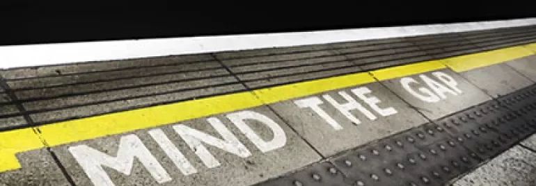 Train platform edge with 'Mind the Gap' warning.
