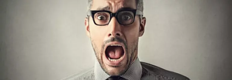 Person wearing glasses and a striped shirt with a surprised expression.