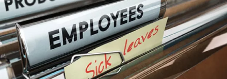 File folders labeled 'Employees' and 'Sick Leaves' in a cabinet.