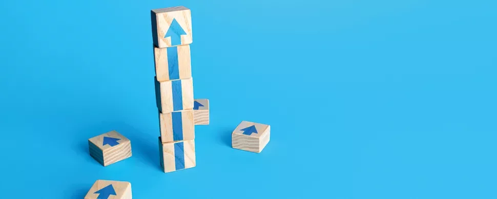 Stacked wooden blocks with blue arrows on a blue background