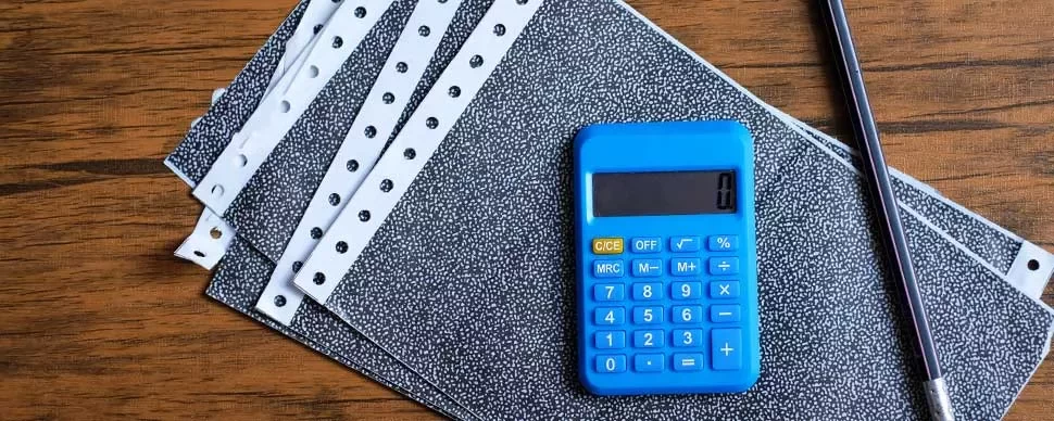 a calculator and pen on top of payslips