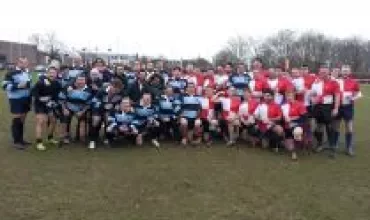Two rugby teams posing together on a field.
