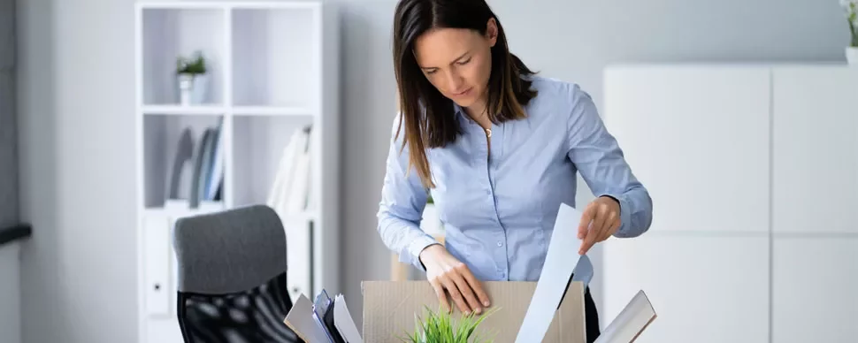 Person unpacking a box in an office setting.