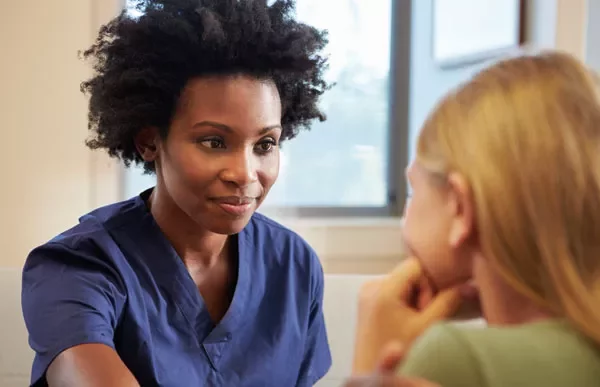 Healthcare professional talking to a patient in an office setting.