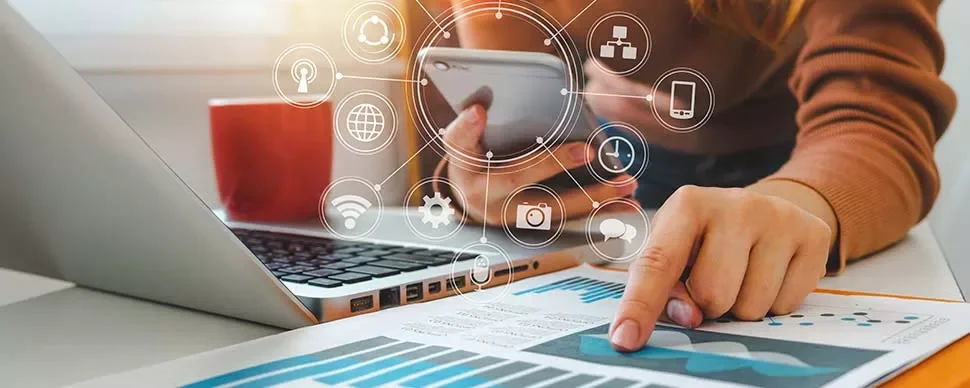 Person using smartphone and laptop with digital icons overlay.