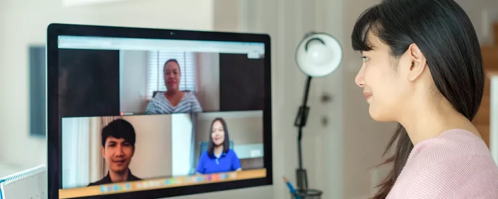 Person participating in a video conference on a desktop screen.