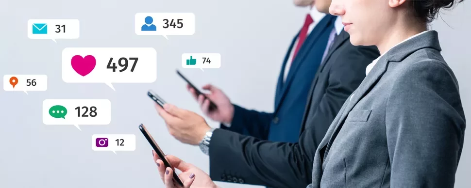 Professionals using smartphones with social media notification icons floating around.