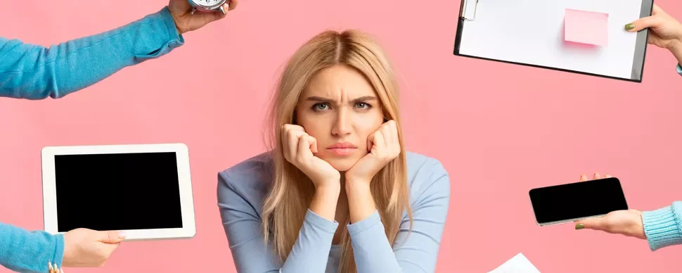 Person looking frustrated while surrounded by digital devices and a clipboard against a pink background.