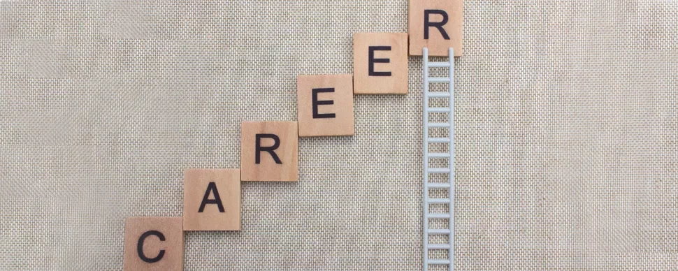 Scrabble tiles spelling 'career' with a ladder connected to the last tile.