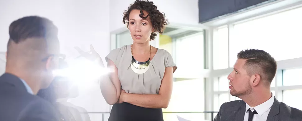 Person speaking to colleagues in a bright office.