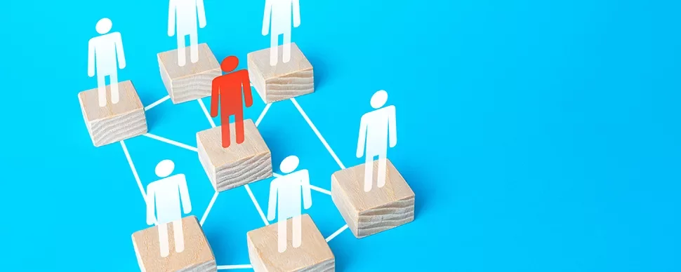 Figure on wooden block network with one highlighted in red on light blue background.