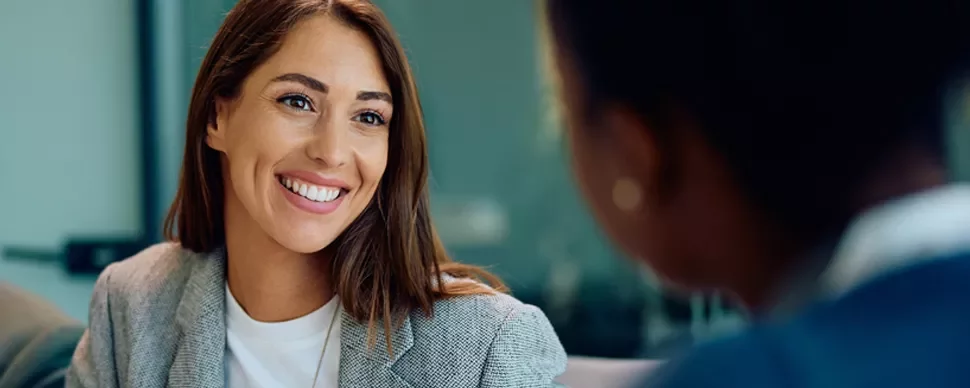close up view of smiling professional woman over the shoulder of an interviewer