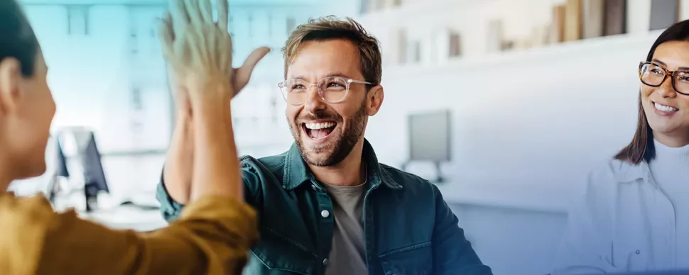 three working professionals, two are giving each a high five