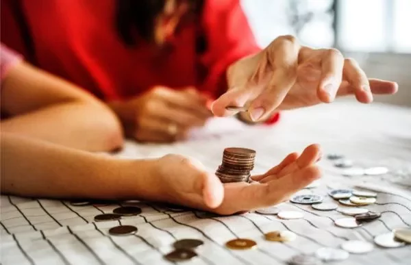Individual counting pennies in their hand 