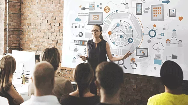 Person giving a presentation on digital network concepts to a group.